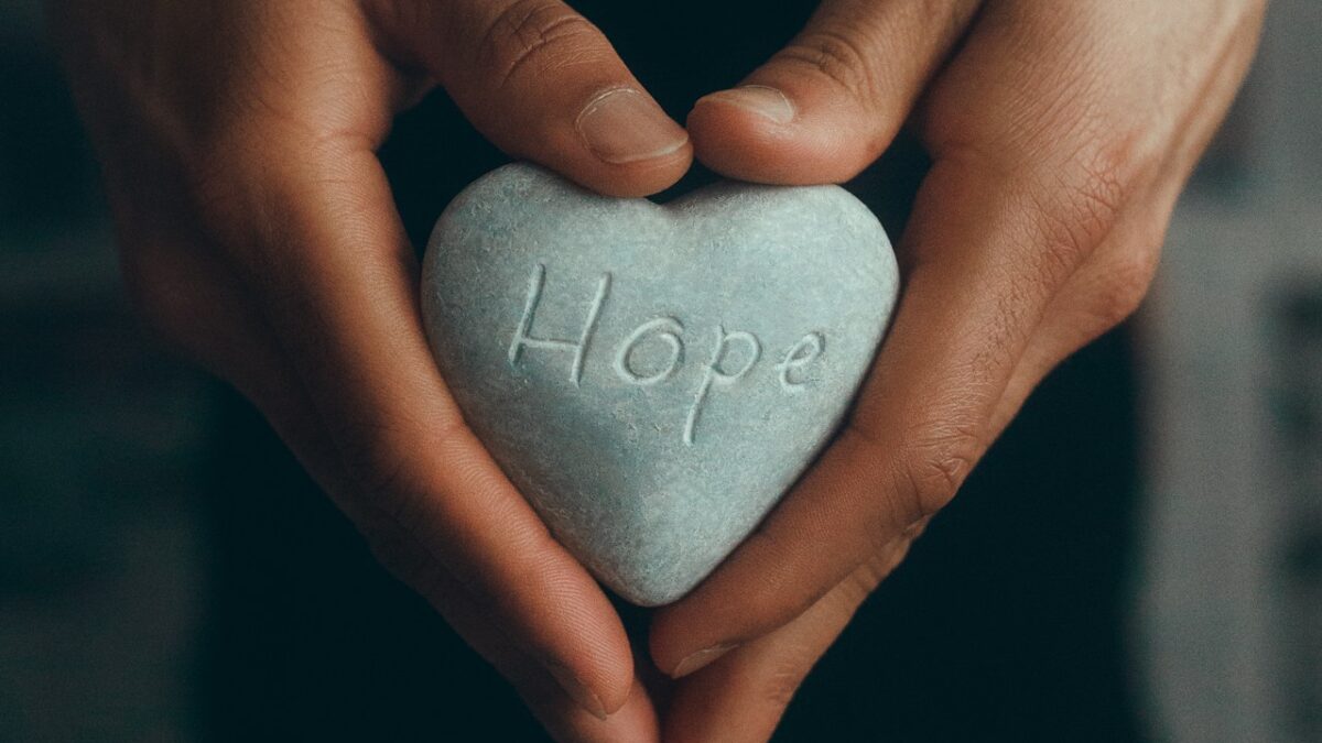 person holding gray heart shape ornament
